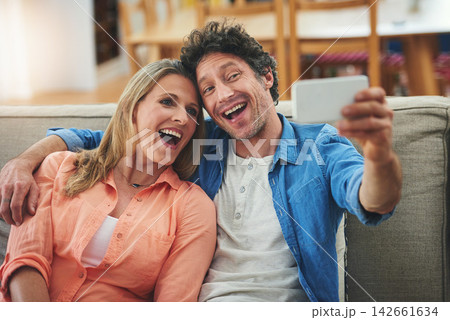 Couple, selfie and couch in home, smile and excited for memory with bonding for love with connection. People, man and woman with embrace for care, happy and profile picture on app for social network Couple, selfie and couch in home, smile and excited for memory with bonding for love with connection. People, man and woman with embrace for care, happy and profile picture on app for social network 142661634