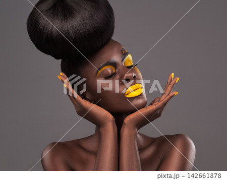 African, woman and studio art with makeup, beauty and creative yellow lipstick. Bold, model and skin with confidence, dramatic hair and bun for glamour or trendy cosmetics on isolated grey background African, woman and studio art with makeup, beauty and creative yellow lipstick. Bold, model and skin with confidence, dramatic hair and bun for glamour or trendy cosmetics on isolated grey background 142661878