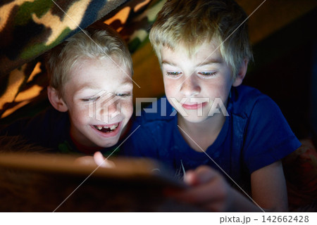 Smile, kids and brothers on tablet in tent at home for game, movie or streaming cartoon online at night together. Happy children, siblings and technology for app, internet or family relax in house 142662428