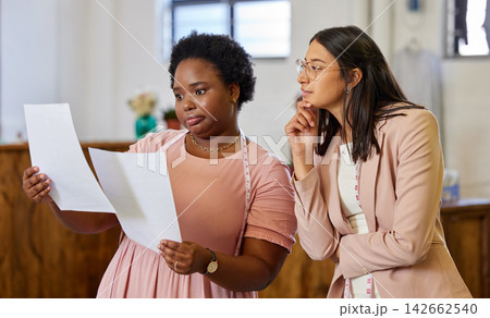 Planning, woman colleagues and talking with thinking, tape and fashion designer in workspace. Pensive, communication and teamwork for coworkers and office, pattern or tailor with small business owner 142662540