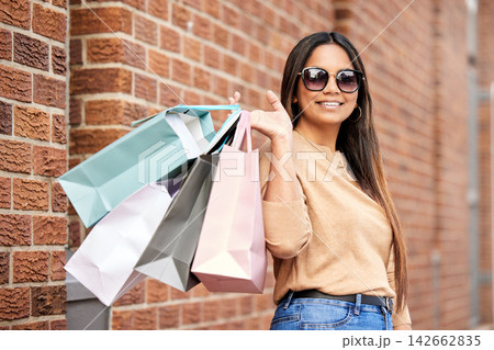Woman, shopping bag and portrait in city happy on urban street for boutique, retail and clothing sale. Female person, sunglasses and smile outdoors with luxury products for fashionable rich customer 142662835