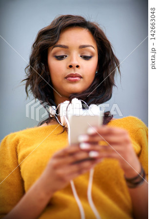 Girl, streaming and phone for music online with headphones, app and download podcast or audiobook. Woman, typing and reading news of hip hop artist on website or listening to album, playlist or sound Girl, streaming and phone for music online with headphones, app and download podcast or audiobook. Woman, typing and reading news of hip hop artist on website or listening to album, playlist or sound 142663048