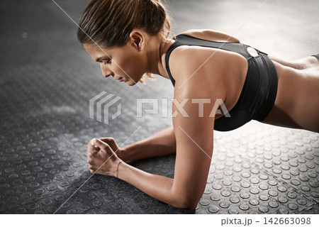 Strength, training and woman with plank in gym for balance, muscle exercise and endurance. Female person, thinking and athlete on ground in health club for fitness, core workout and challenge 142663098