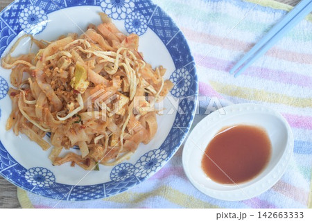 Pad Thai stir fried rice noodles with egg and bean sprout couple garlic chive on plate dipping chili sauce Pad Thai stir fried rice noodles with egg and bean sprout couple garlic chive on plate dipping chili sauce 142663333