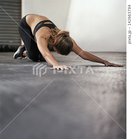 Woman, gym and floor with stretching for back with arms, exercise or fitness for health. Female person, flexible and hands out for wellness with training, commitment to sport or workout with care 142663784