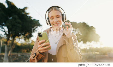 Businesswoman, headphones and cellphone or park walking for work commute, streaming or podcast. Female person, dance and happiness in urban city for morning travel with music, entertainment or audio Businesswoman, headphones and cellphone or park walking for work commute, streaming or podcast. Female person, dance and happiness in urban city for morning travel with music, entertainment or audio 142663886