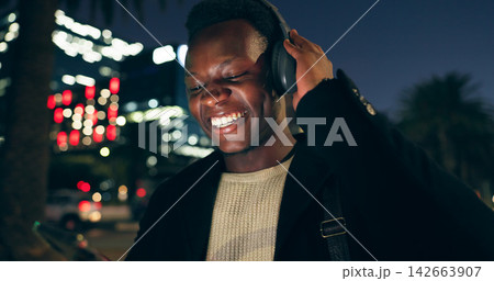 Black man, outdoor and dancing on smartphone with headphone for music playlist, entertainment at night in New York. Female person, happy and internet for streaming platform with song and video 142663907