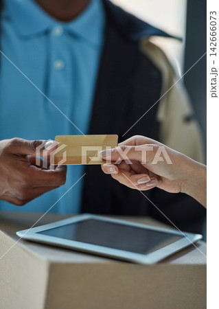 Credit card, delivery man and hands of person at with tablet, package and online shopping sales or distribution service at door. Ecommerce, courier and customer with box, easy payment and POS at home Credit card, delivery man and hands of person at with tablet, package and online shopping sales or distribution service at door. Ecommerce, courier and customer with box, easy payment and POS at home 142666073