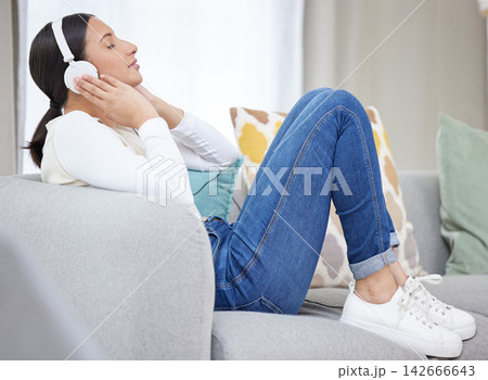 Headphones, music and woman on sofa in home for relaxing, resting and chill on weekend. Happy, smile and person on couch listening to audio, song and radio on streaming subscription in living room Headphones, music and woman on sofa in home for relaxing, resting and chill on weekend. Happy, smile and person on couch listening to audio, song and radio on streaming subscription in living room 142666643