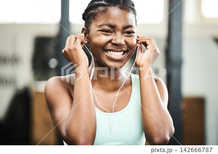 Earphones, healthy and black girl in gym, music and listening for exercise, online and streaming on app. Fitness, audio and practice with technology, internet and radio for wellness and training Earphones, healthy and black girl in gym, music and listening for exercise, online and streaming on app. Fitness, audio and practice with technology, internet and radio for wellness and training 142666787