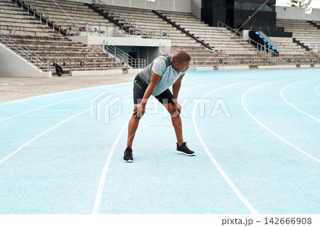 Black man, athlete and breathing after running on track for exercise, fitness and cardio in stadium. African male person, workout and runner on outdoor field for sports, health and wellness Black man, athlete and breathing after running on track for exercise, fitness and cardio in stadium. African male person, workout and runner on outdoor field for sports, health and wellness 142666908