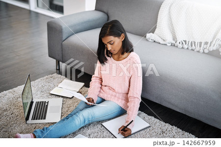 Female student, laptop and notes on floor in lounge for learning and studying for education in house on weekend. Young person or scholar with tech and notebook for research, exam test and writing Female student, laptop and notes on floor in lounge for learning and studying for education in house on weekend. Young person or scholar with tech and notebook for research, exam test and writing 142667959