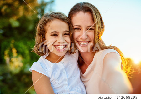 Happy, mother and young girl in selfie for bonding together outside in nature with love, care and support at home. Excited, family and smile in portrait to relax, play and have fun in summer holiday 142668295