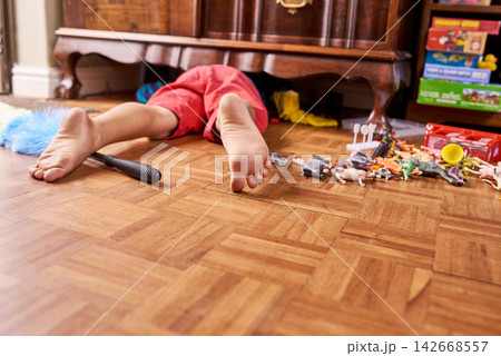 Child, looking and cupboard on floor in home for lost toy or dust cleaning for chores, playroom or messy. Person, legs and under closet for searching in apartment on ground with feet, youth or tidy Child, looking and cupboard on floor in home for lost toy or dust cleaning for chores, playroom or messy. Person, legs and under closet for searching in apartment on ground with feet, youth or tidy 142668557