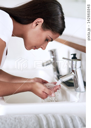 Woman, sink and wash face for treatment, routine and hygiene in bathroom for skincare. Female person, grooming and beauty with water for makeup removal, glow and fresh skin for wellness or care Woman, sink and wash face for treatment, routine and hygiene in bathroom for skincare. Female person, grooming and beauty with water for makeup removal, glow and fresh skin for wellness or care 142668848