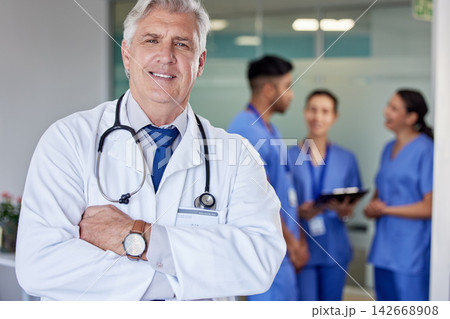Senior doctor, man and arms crossed in portrait at hospital with confidence, smile and healthcare services. Mature medic, expert or specialist with pride for professional career with staff in clinic 142668908