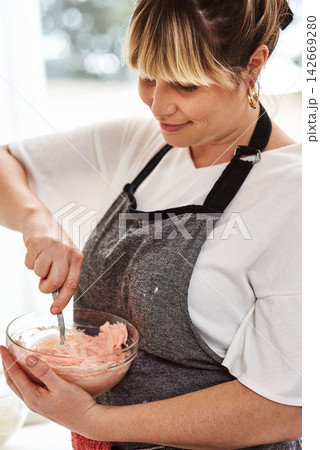 Woman, kitchen and icing for dessert, home and glass bowl for baking or small business. Baker, ingredients and mixing with spoon, house or startup bakery for recipe prepare and sweet food process Woman, kitchen and icing for dessert, home and glass bowl for baking or small business. Baker, ingredients and mixing with spoon, house or startup bakery for recipe prepare and sweet food process 142669280