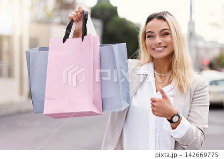 Thumbs up, shopping and portrait of woman with bags in city for bargain, boutique sale or discount. Fashion, hand gesture and female customer in street for luxury products, retail purchase or deal Thumbs up, shopping and portrait of woman with bags in city for bargain, boutique sale or discount. Fashion, hand gesture and female customer in street for luxury products, retail purchase or deal 142669775