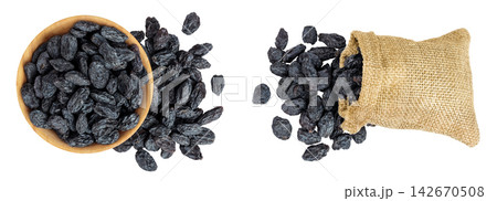 black raisins in bag and wooden bowl isolated on white background. Top view. Flat lay 142670508