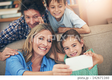 Happy family, relax and selfie with peace sign on sofa for memory, picture or bonding together at home. Mom, dad and young children with smile for photography, capture or moment on living room couch 142671160
