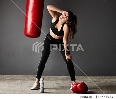 Punching bag, tired boxer or woman on break in boxing training, exercise or workout in gym studio. Sweating, sports athlete or exhausted girl with fatigue, fitness or water bottle on grey background 142671513
