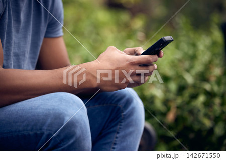 Garden, hands and phone with person outdoor for app, social media or text message communication closeup. Contact, technology or typing and user with mobile in park for browsing, searching or info 142671550