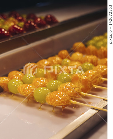 Ddalgi Satang, Fruit Hard Candy on stick skewers, candied strawberry, grape and tangerine in hardened sugar, traditional street food selection, Seoul, South Korea, local tasty dishes on night market 142672553