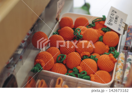 Tourist gifts and Korean souvenirs from Jeju Island, Jeju-do, South Korea, tangerine hallabong figures in orange color, knitted toys, fridge magnets, key ring keychain, a local gift vendor shop market 142673182