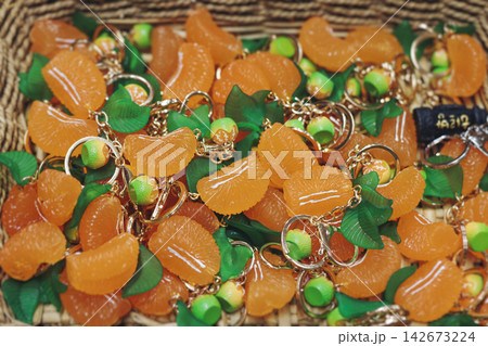 Tourist gifts and Korean souvenirs from Jeju Island, Jeju-do, South Korea, tangerine hallabong figures in orange color, knitted toys, fridge magnets, key ring keychain, a local gift vendor shop market 142673224