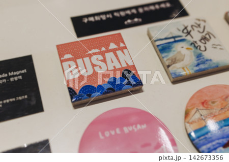 Tourist gifts and Korean souvenirs from Busan, South Korea,  toys and figurines, fridge magnets and key ring keychain, key fobs and postcards with symbols of Busan in a local gift vendor shop market 142673356
