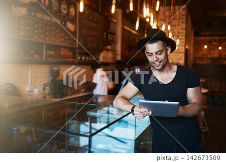Tablet, man and coffee shop with creative job and digital freelancer planning a social media post or blog. Smile, restaurant and tech with happy writer with remote work at cafe with internet Tablet, man and coffee shop with creative job and digital freelancer planning a social media post or blog. Smile, restaurant and tech with happy writer with remote work at cafe with internet 142673509