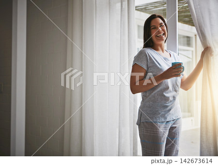 Woman, coffee and open curtain in morning, glass door and fresh wake up with sunrise in hotel ready for day. Routine, outside view and holiday or weekend, drapes and light in apartment in bedroom 142673614