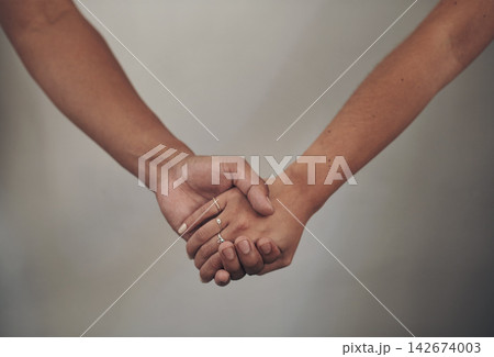 Couple, love and holding hands for support, care and solidarity or romance with studio background. Compassion, partnership or relationship for people, marriage or hope or trust for affection together Couple, love and holding hands for support, care and solidarity or romance with studio background. Compassion, partnership or relationship for people, marriage or hope or trust for affection together 142674003