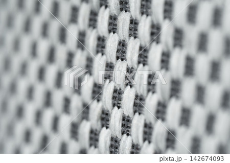 Mattress. The background features a macrotexture made of white-and-gray woven fabric. 142674093