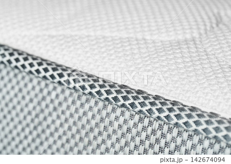 The macrotexture of the white edging and the fabric of the orthopedic mattress. The macrotexture of the white edging and the fabric of the orthopedic mattress. 142674094