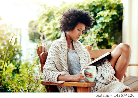 Black woman, reading and coffee for outside in nature, book and backyard or garden for relax. Patio, bench and tea cup for calm and break in home for female person, morning or outdoors in house 142674120