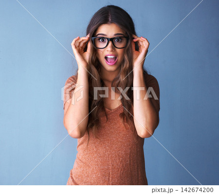 Woman, glasses and surprise in studio portrait, shock and deal for optometry sale with mock up space. Customer, hand gesture for wow expression, promotion and crazy news or announcement offer Woman, glasses and surprise in studio portrait, shock and deal for optometry sale with mock up space. Customer, hand gesture for wow expression, promotion and crazy news or announcement offer 142674200