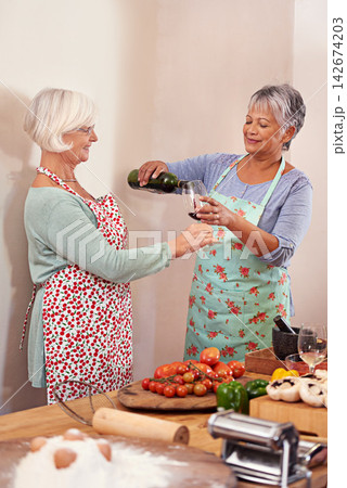 Wine, food and happy senior women in home for toast to lunch, supper and dinner together with friends. Alcohol, cooking and mature people with drink, bottle and glass for celebration, party and event Wine, food and happy senior women in home for toast to lunch, supper and dinner together with friends. Alcohol, cooking and mature people with drink, bottle and glass for celebration, party and event 142674203