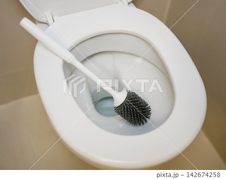 White toilet bowl with a toilet brush in a clean modern bathroom, representing household cleaning, hygiene, sanitation, restroom maintenance and everyday home care. White toilet bowl with a toilet brush in a clean modern bathroom, representing household cleaning, hygiene, sanitation, restroom maintenance and everyday home care. 142674258