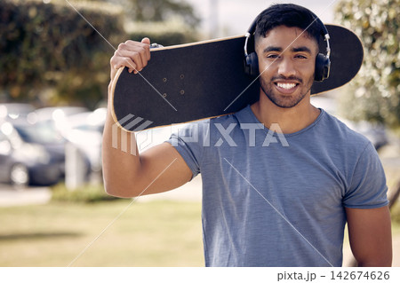 Man, headphones and portrait with skateboard in park or music playlist, exercise or hobby. Male person, smile and streaming podcast for learning skill or fun workout for online, training or confident 142674626