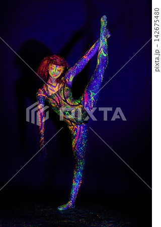 Body paint, dance and woman in studio for art, culture and stretching in neon fantasy aesthetic. Creative, design and girl in color makeup for dance, identity or unique character on black background Body paint, dance and woman in studio for art, culture and stretching in neon fantasy aesthetic. Creative, design and girl in color makeup for dance, identity or unique character on black background 142675480