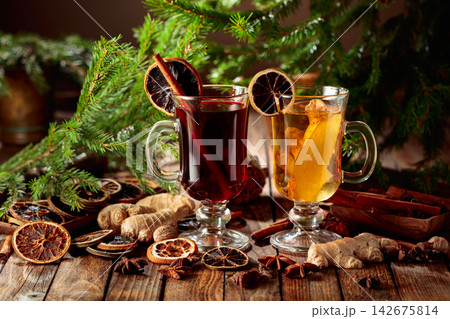 Mulled wine and ginger tea with spices and dried citrus on an old wooden table. Mulled wine and ginger tea with spices and dried citrus on an old wooden table. 142675814
