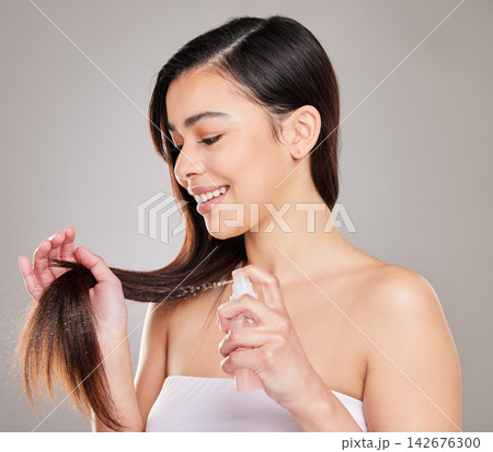 Happy, woman and hands for haircare with spray or keratin serum for growth and product placement . Female person or model and smooth texture from luxury treatment for healthy natural hair in studio 142676300