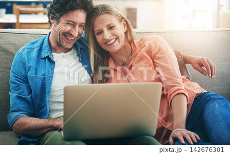 Mature, couple and laughing with laptop in home for comedy movie, funny series or streaming service on sofa. People, technology and comic video on couch with relax, embrace or entertainment in lounge Mature, couple and laughing with laptop in home for comedy movie, funny series or streaming service on sofa. People, technology and comic video on couch with relax, embrace or entertainment in lounge 142676301
