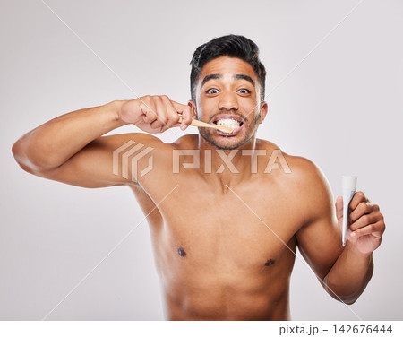 Brushing teeth, man and portrait in studio for hygiene, clean or routine on white background. Indian male person, dental or plaque treatment with toothbrush for self care, wellness or freshness Brushing teeth, man and portrait in studio for hygiene, clean or routine on white background. Indian male person, dental or plaque treatment with toothbrush for self care, wellness or freshness 142676444