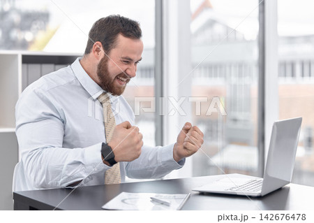 Fist pump, laptop and businessman in office with happy for winning, job promotion or career achievement. Smile, technology and trader with finance stock market on computer to celebrate at workplace. Fist pump, laptop and businessman in office with happy for winning, job promotion or career achievement. Smile, technology and trader with finance stock market on computer to celebrate at workplace. 142676478