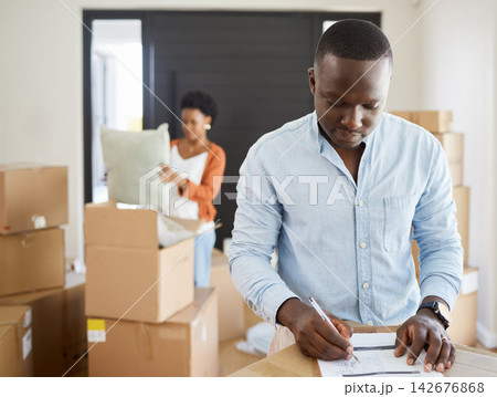African, couple and boxes on checklist in apartment for moving, house and relocation on couch in living room. Woman, man and paper for plan in packing for future, new home or property as young people African, couple and boxes on checklist in apartment for moving, house and relocation on couch in living room. Woman, man and paper for plan in packing for future, new home or property as young people 142676868