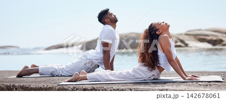 Couple, yoga and beach for wellness on mat, relationship bonding and body health or stretch with exercise. Spiritual, holistic training and trust or outdoor meditation, ocean and mindfulness practice 142678061