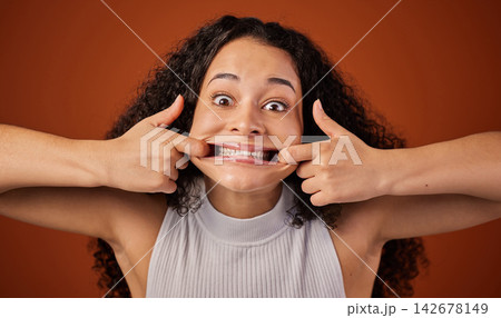 Girl, portrait and pulling in studio, mouth and stretch cheek for comedy on red background. Female person, comic and silly or goofy humor for joke, emoji and confident funny face on mockup space Girl, portrait and pulling in studio, mouth and stretch cheek for comedy on red background. Female person, comic and silly or goofy humor for joke, emoji and confident funny face on mockup space 142678149