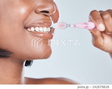 Black woman, closeup and mouth with toothbrush for dental hygiene on a white studio background. Young African, female person or model with smile in satisfaction for oral, gum care or morning routine Black woman, closeup and mouth with toothbrush for dental hygiene on a white studio background. Young African, female person or model with smile in satisfaction for oral, gum care or morning routine 142678626